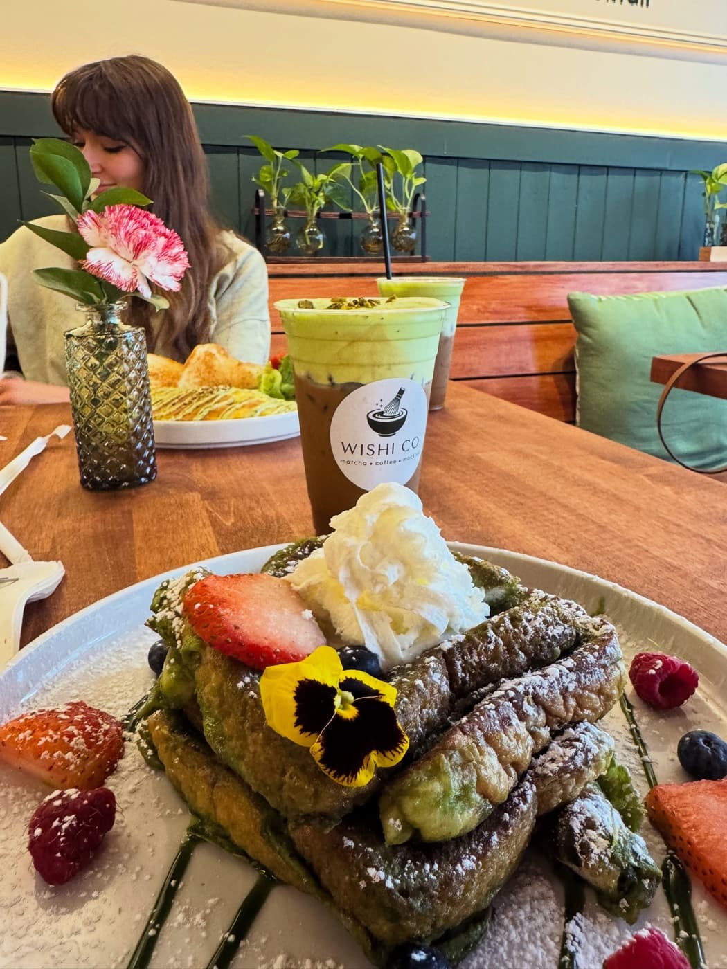A guest enjoying brunch and matcha in the Wishi Co. dining room.